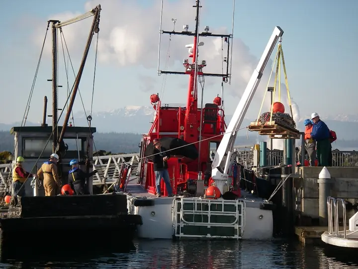 CASCADE and crew working alongside a dock with crane deployed